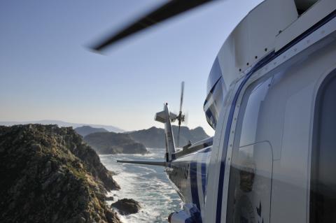 Helicóptero Pesca 1 volando sobre rocas en el mar