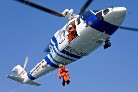Helicóptero Pesca 1 con un tripulante descendiendo por el cable