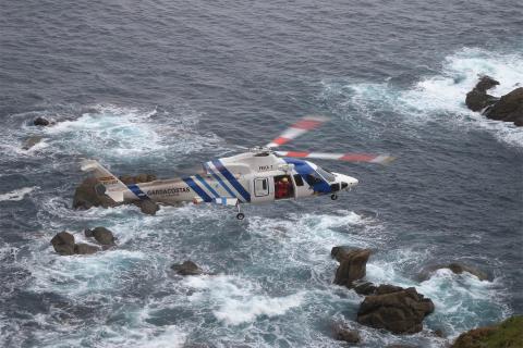 Helicóptero Pesca 2 sobrevolando rocas en el mar
